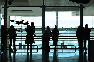 silhouette of group of people standing inside an airport